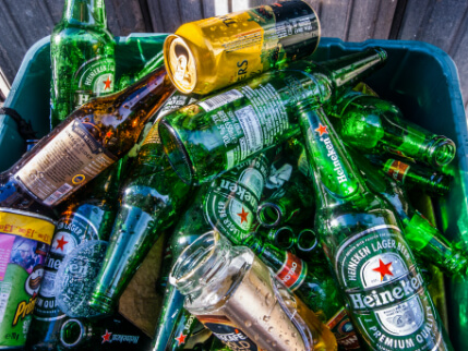 Glass bottles piled in a bin.