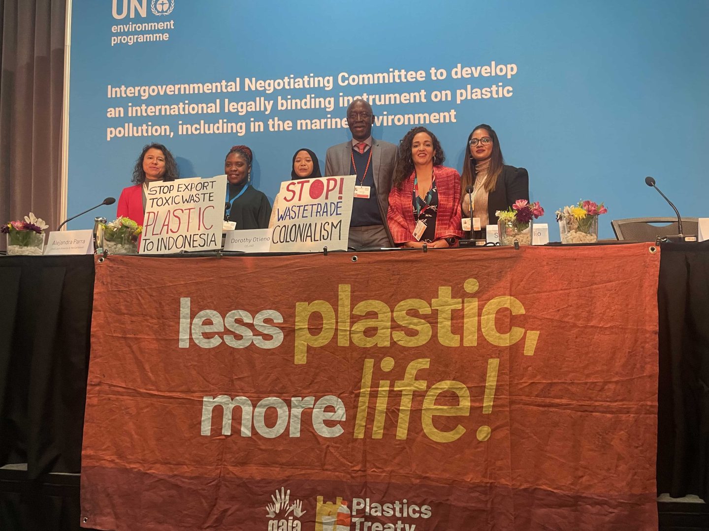 Global South leaders pose for a photo after the press briefing behind a streamer that says less plastic more life. They are also holding 2 placards that say stop waste trade, waste colonialism; and stop export toxic waste plastic to Indonesia